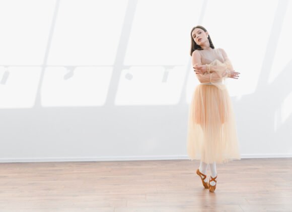 ballerina posing in dance studio with arms crossed utc