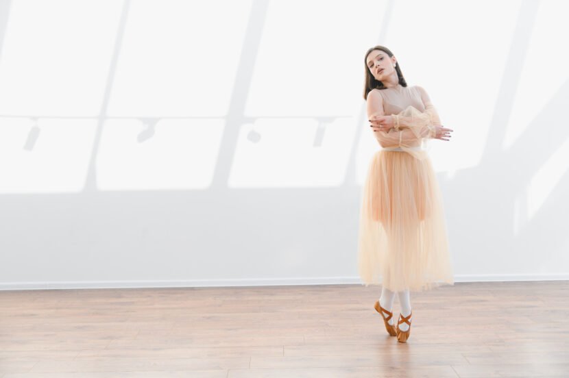 ballerina posing in dance studio with arms crossed utc