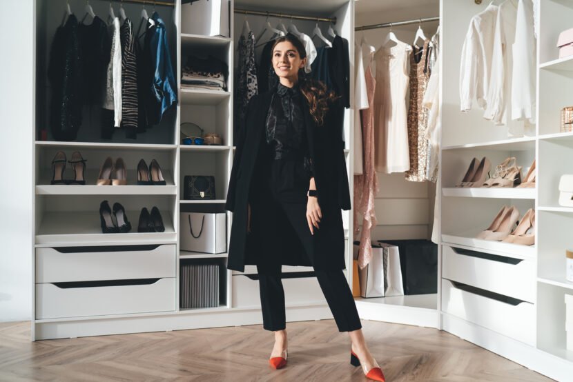 cheerful stylish woman standing in wardrobe utc