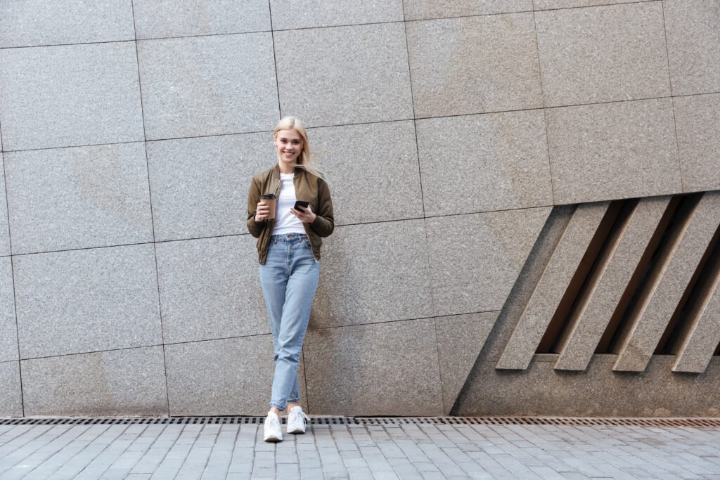 full length shot of young woman with cup of coffee utc