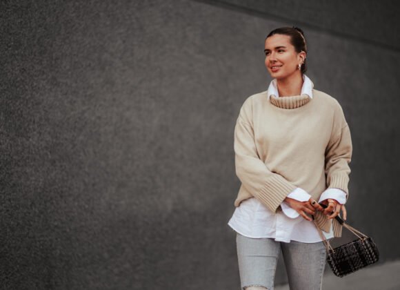 happy fashionable young woman walking on city stre utc