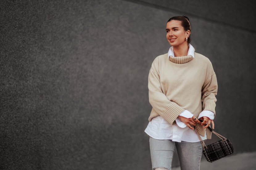 happy fashionable young woman walking on city stre utc
