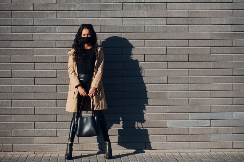 in protective mask beautiful brunette with curly utc