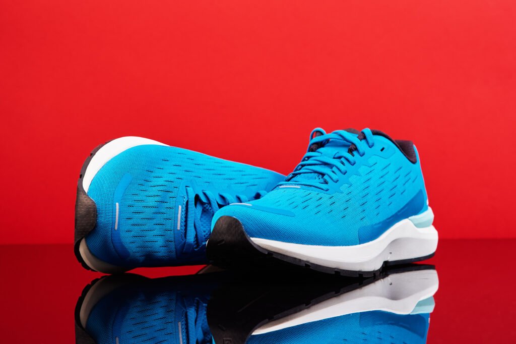 pair of blue running sneakers on red background utc