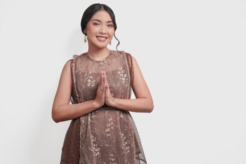 peaceful young asian woman in brown brocade dress utc