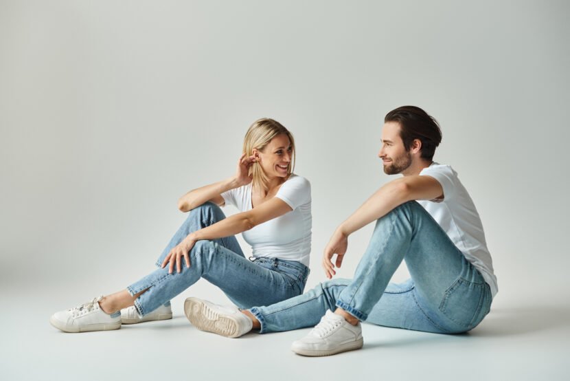 serene lovebirds in jeans sitting and looking at e utc