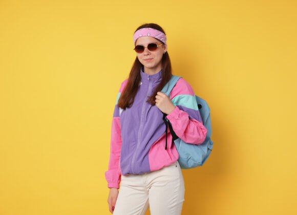 teenage girl in sunglasses with backpack on yellow utc