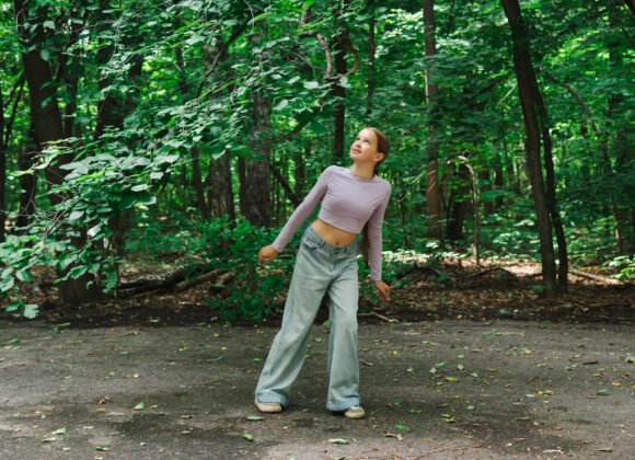 teenage girl smiling and looking through tree bran utc