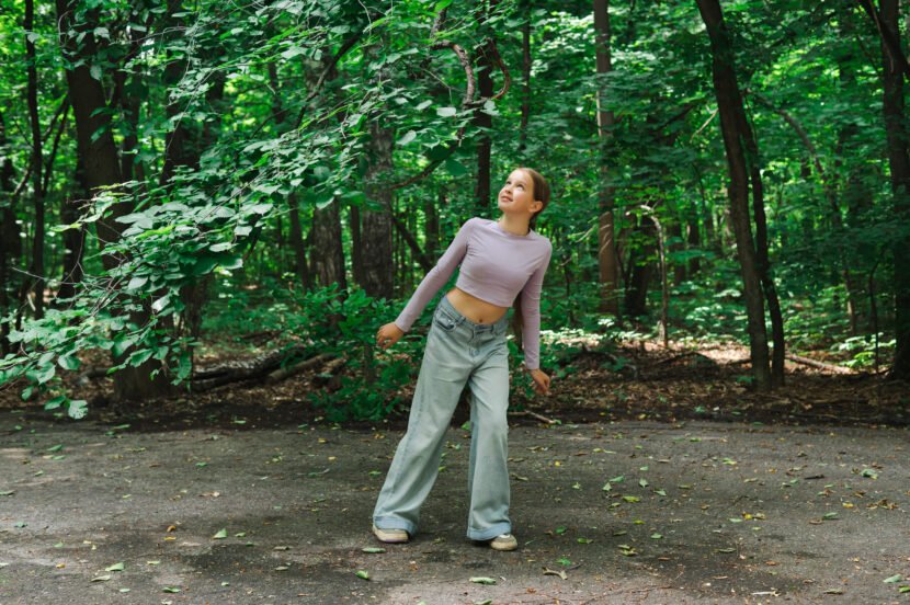 teenage girl smiling and looking through tree bran utc