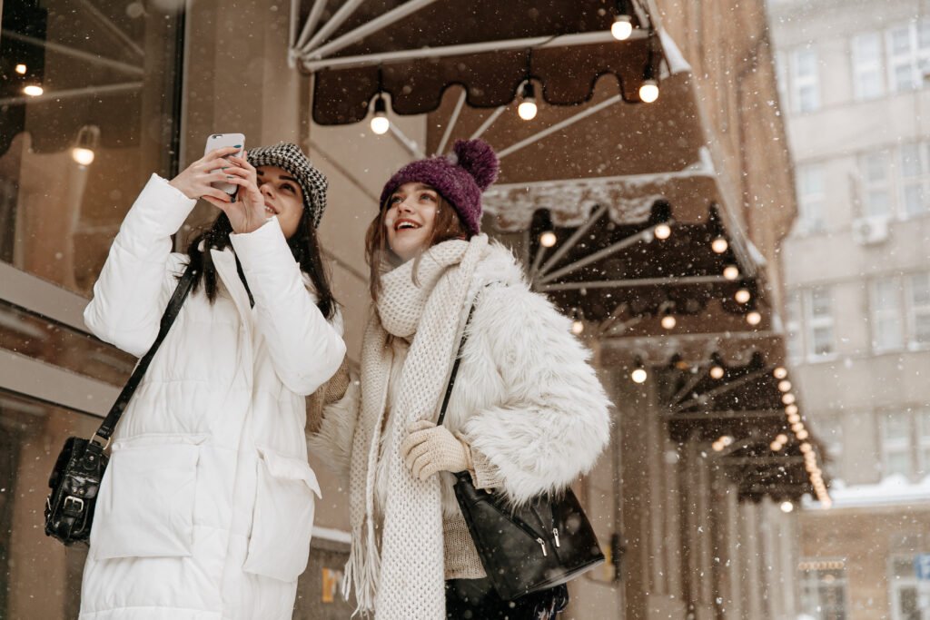 two cheerful women doing pictures of falling snow utc