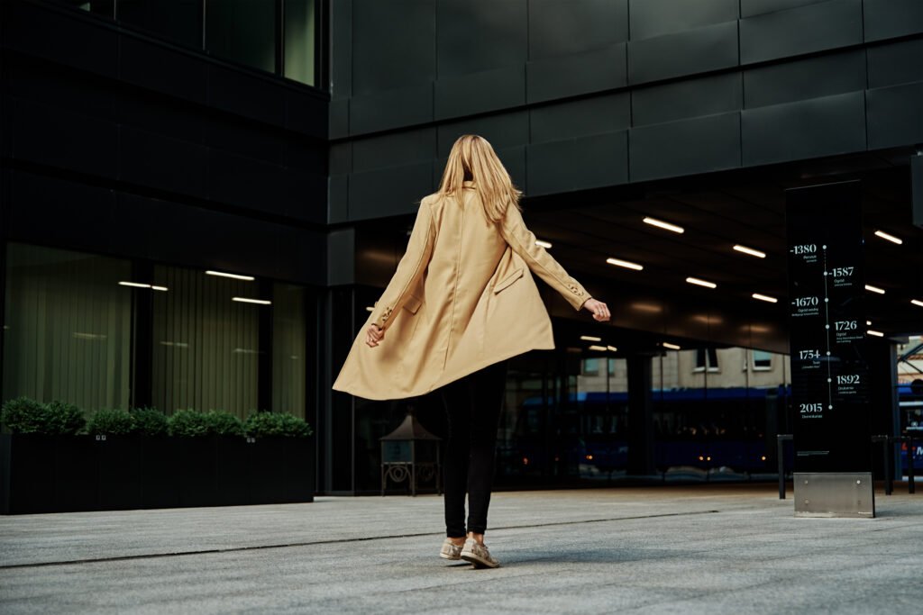 woman in coat walks at city stret utc